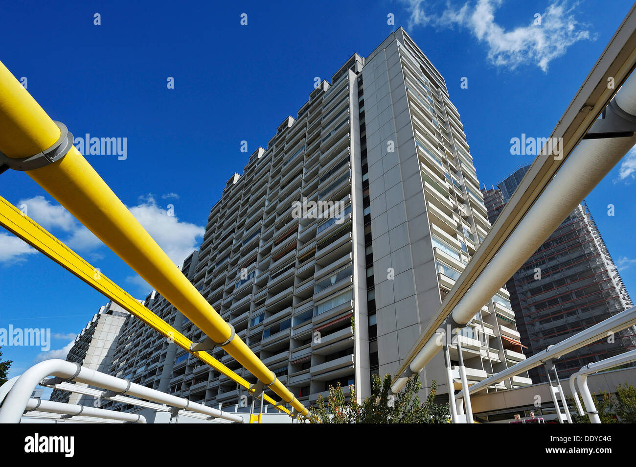 Un edificio multipiano e tubi di alimentazione nell'ex villaggio olimpico, Monaco di Baviera Foto Stock