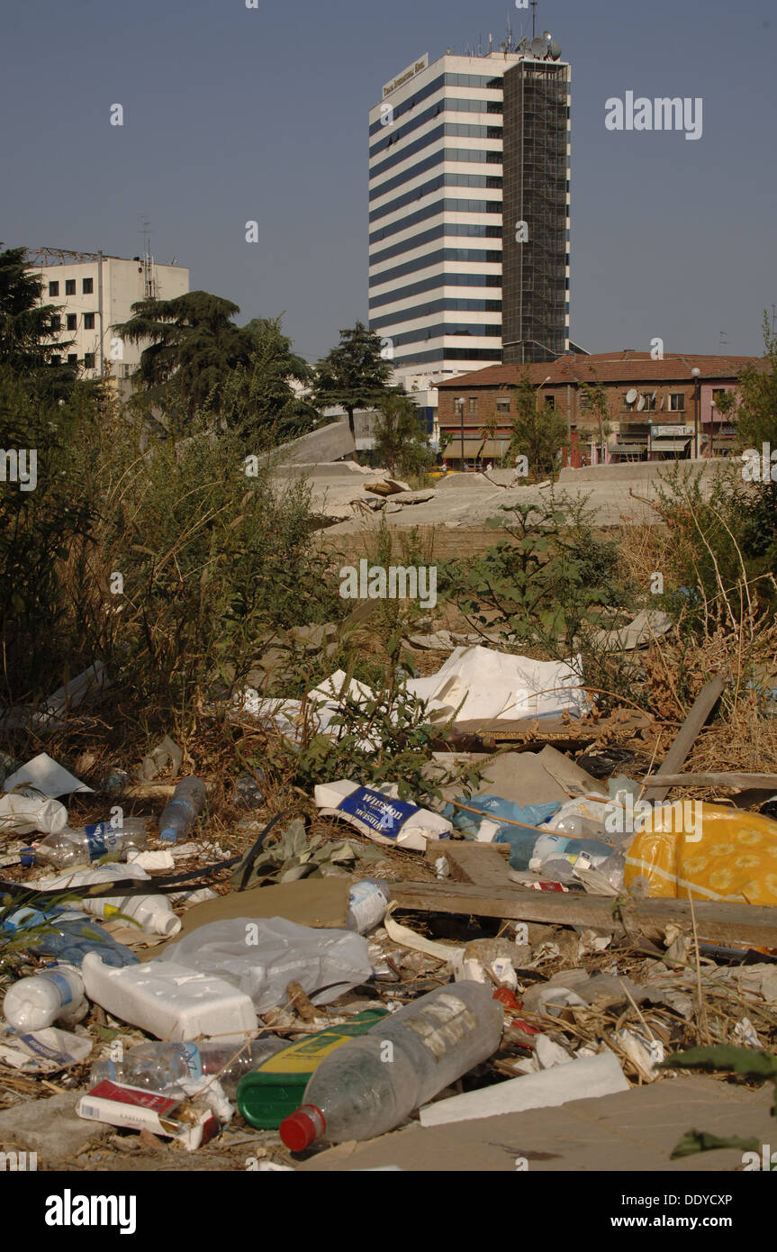 Repubblica di Albania. Tirana. La spazzatura in strada. Sullo sfondo, la International Hotel. Foto Stock