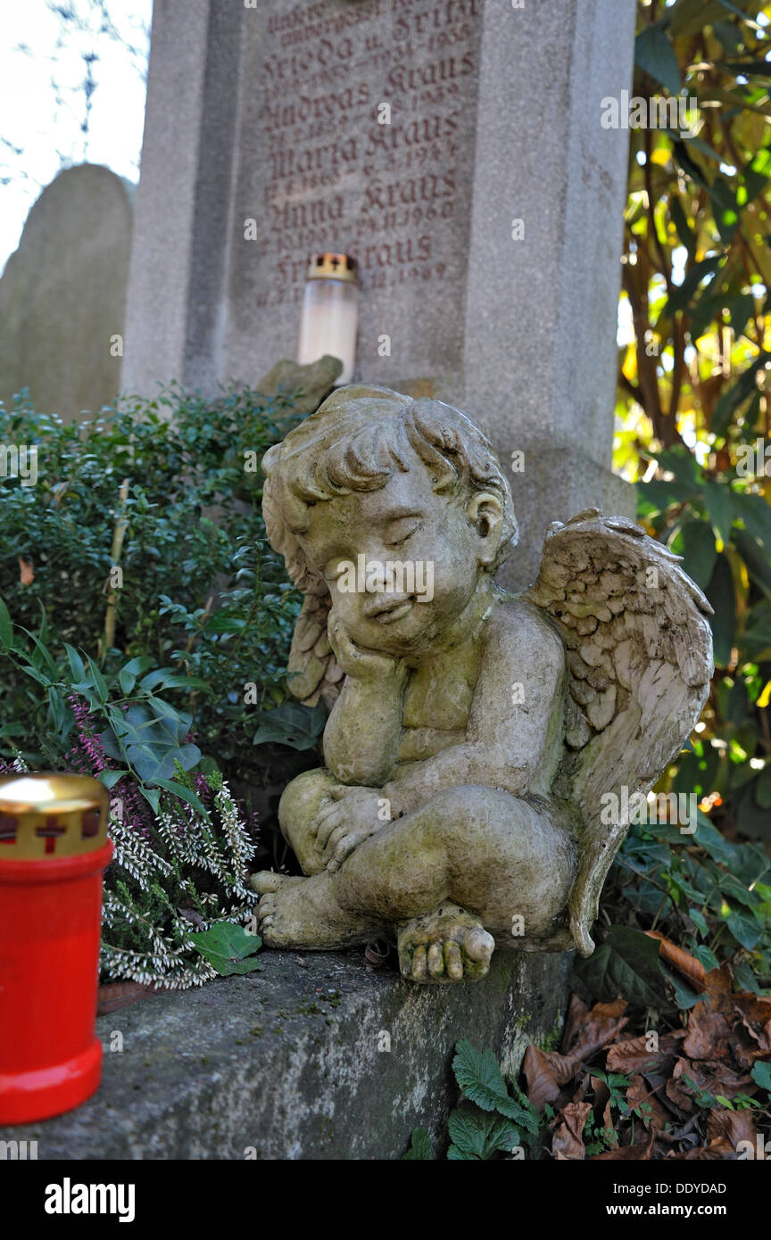 Putto e candela votiva con foglie di autunno sul Ostfriedhof o est cimitero, Monaco di Baviera Foto Stock