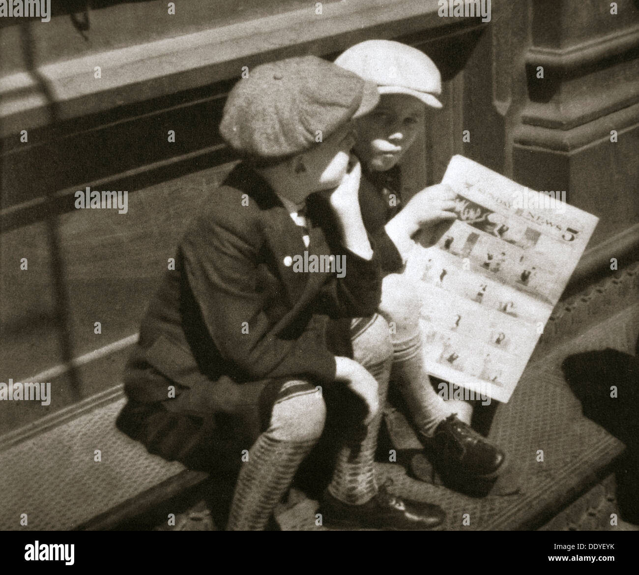 Due ragazzi la lettura della sezione di fumetti della domenica carta, New York, USA, 1931. Artista: sconosciuto Foto Stock
