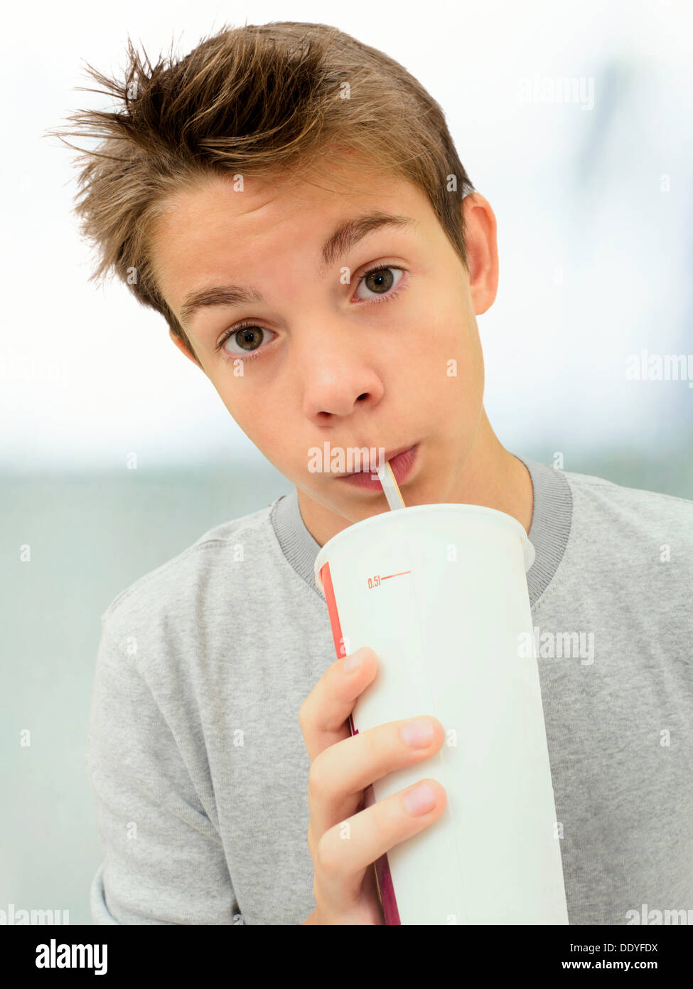 Ritratto, boy, adolescente di bere da un bicchiere con una cannuccia Foto Stock