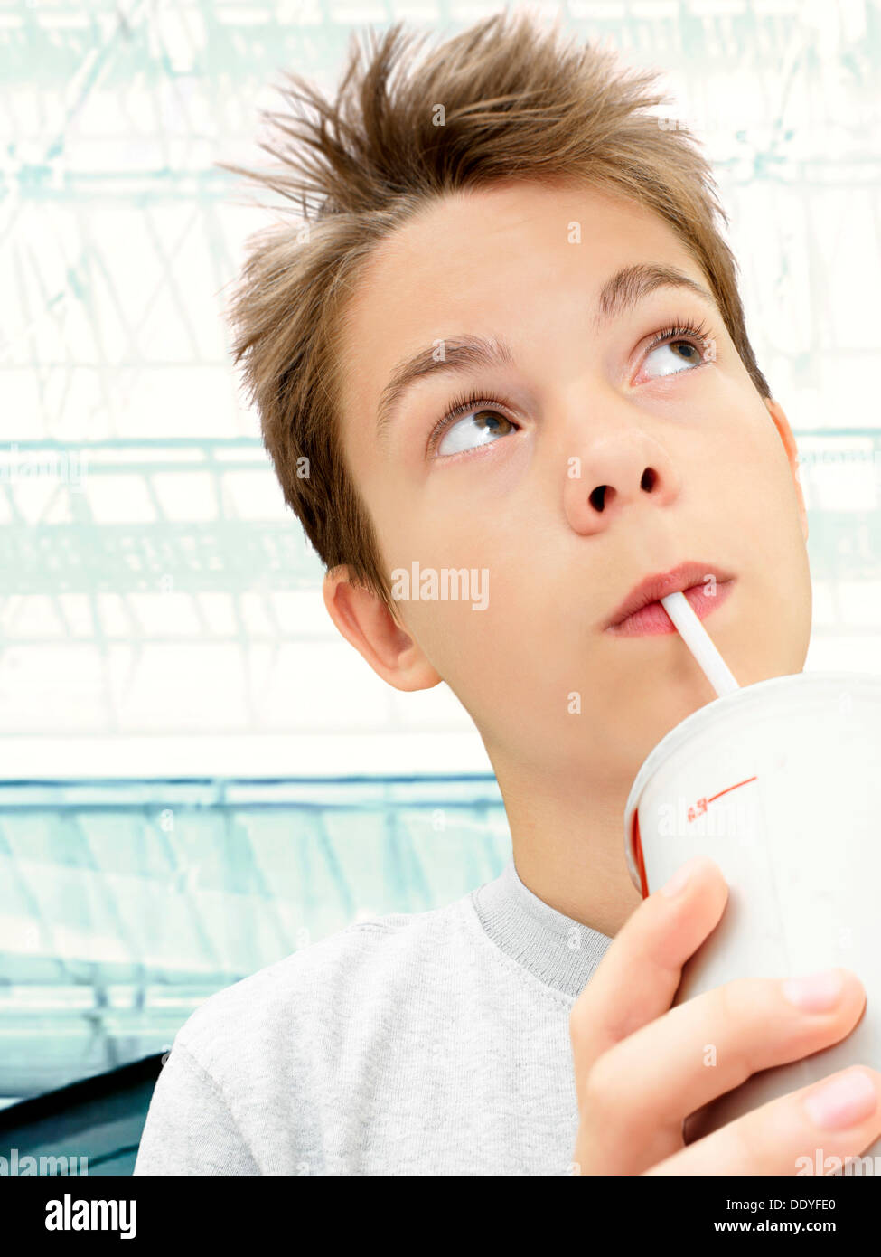 Ritratto, boy, adolescente di bere da un bicchiere con una cannuccia Foto Stock