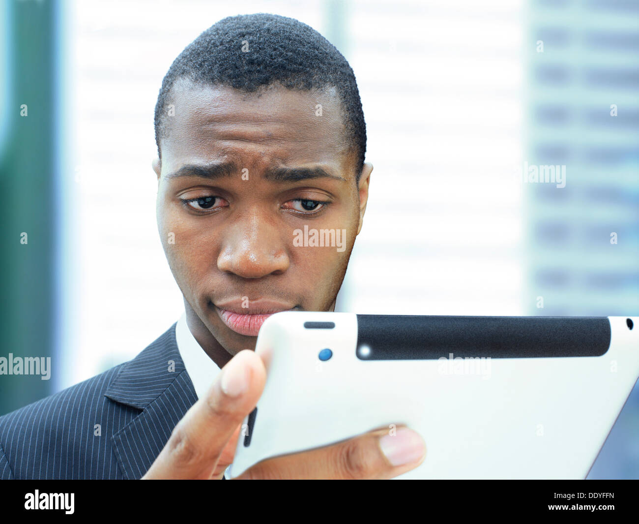 Giovane imprenditore, afro-americani, americani, rispettabile, focalizzata, guardando al suo iPad Foto Stock