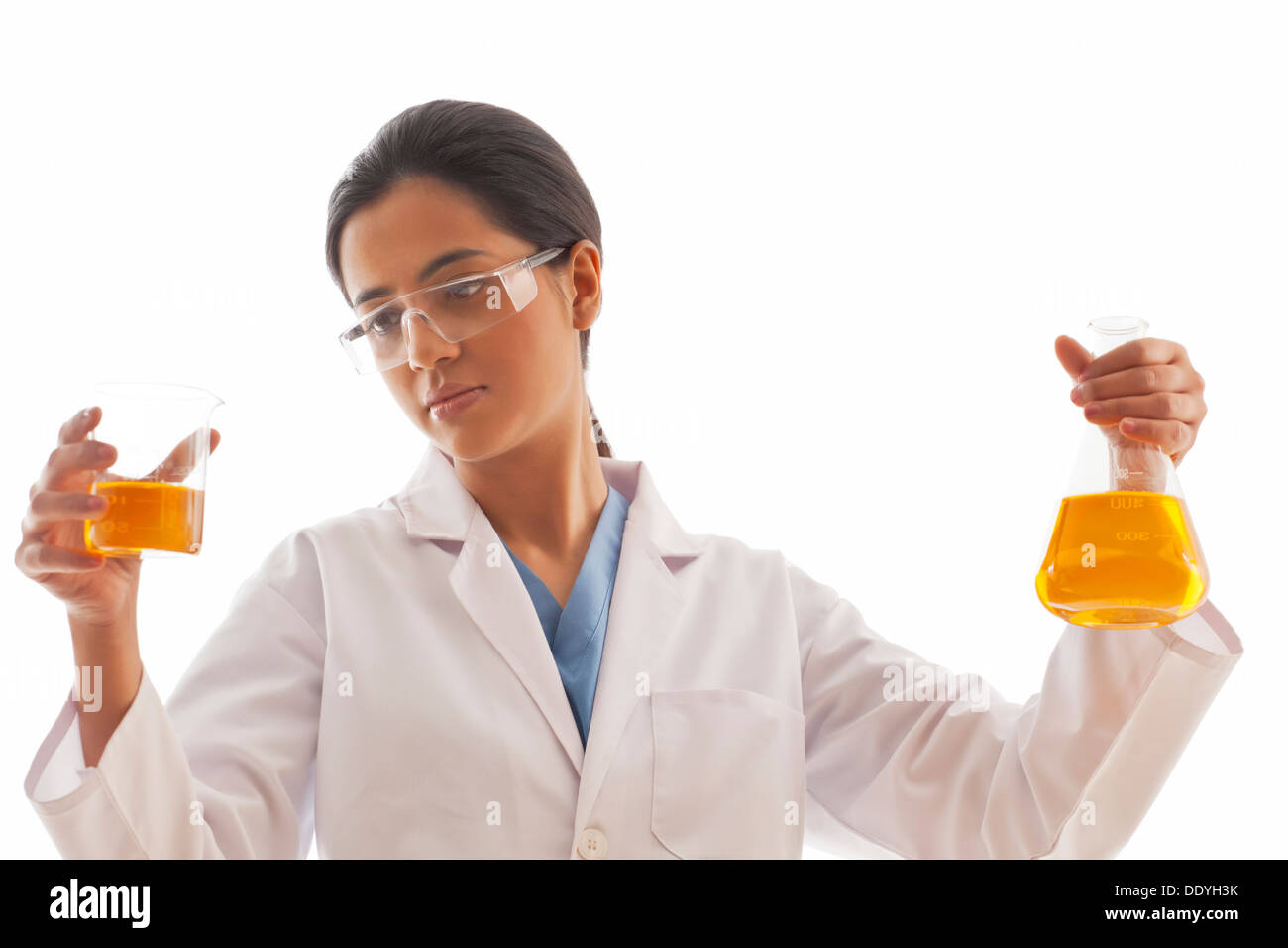 Donna scienziato holding becher e matracci riempito con liquido giallo isolato su sfondo bianco Foto Stock