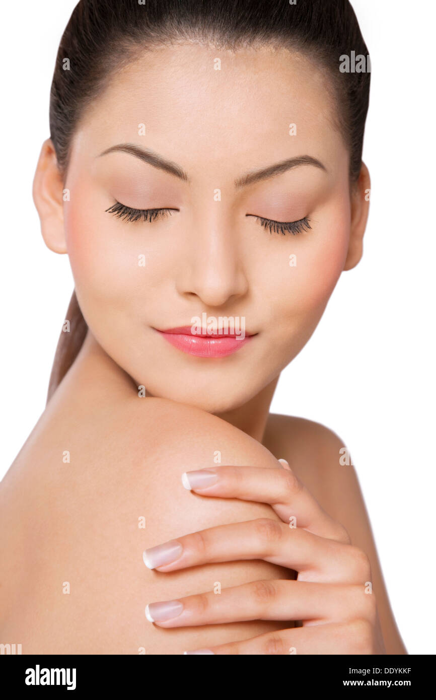 Close-up di giovane donna con gli occhi chiusi di toccare la sua spalla Foto Stock