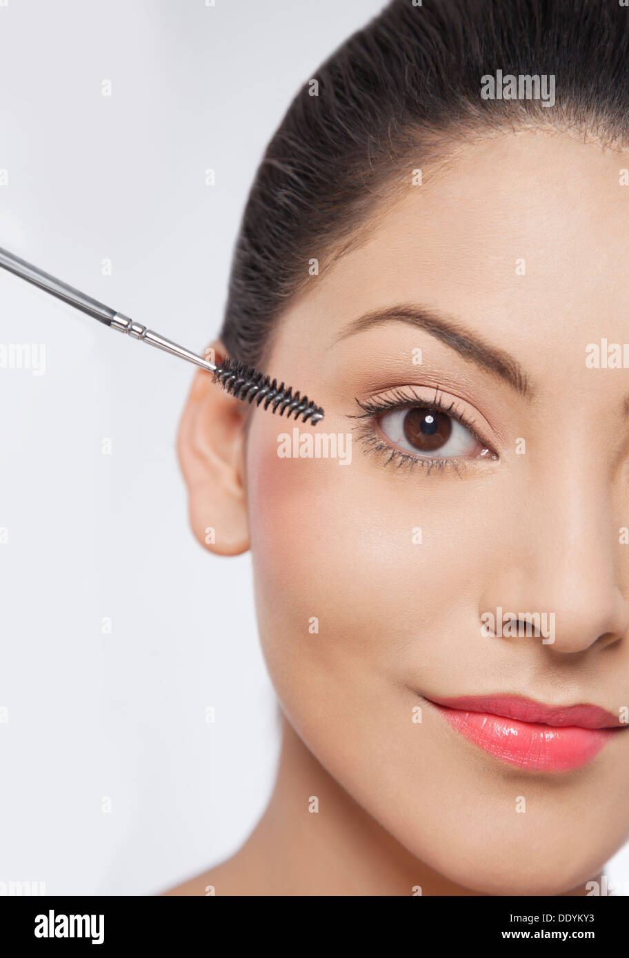Bella giovane donna applicazione di mascara Foto Stock