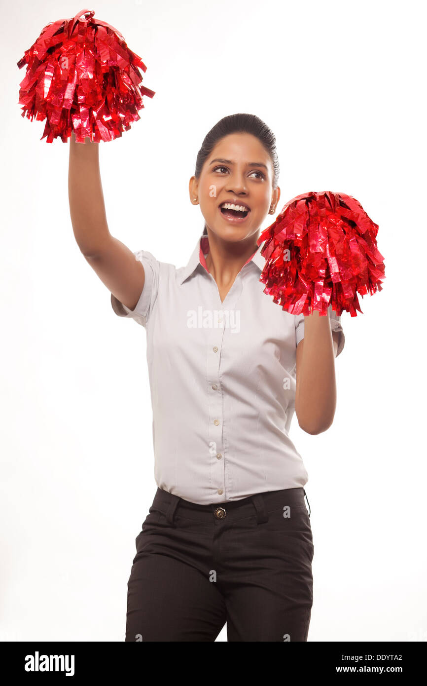 Happy cheer leader con pompon in piedi contro uno sfondo bianco Foto Stock