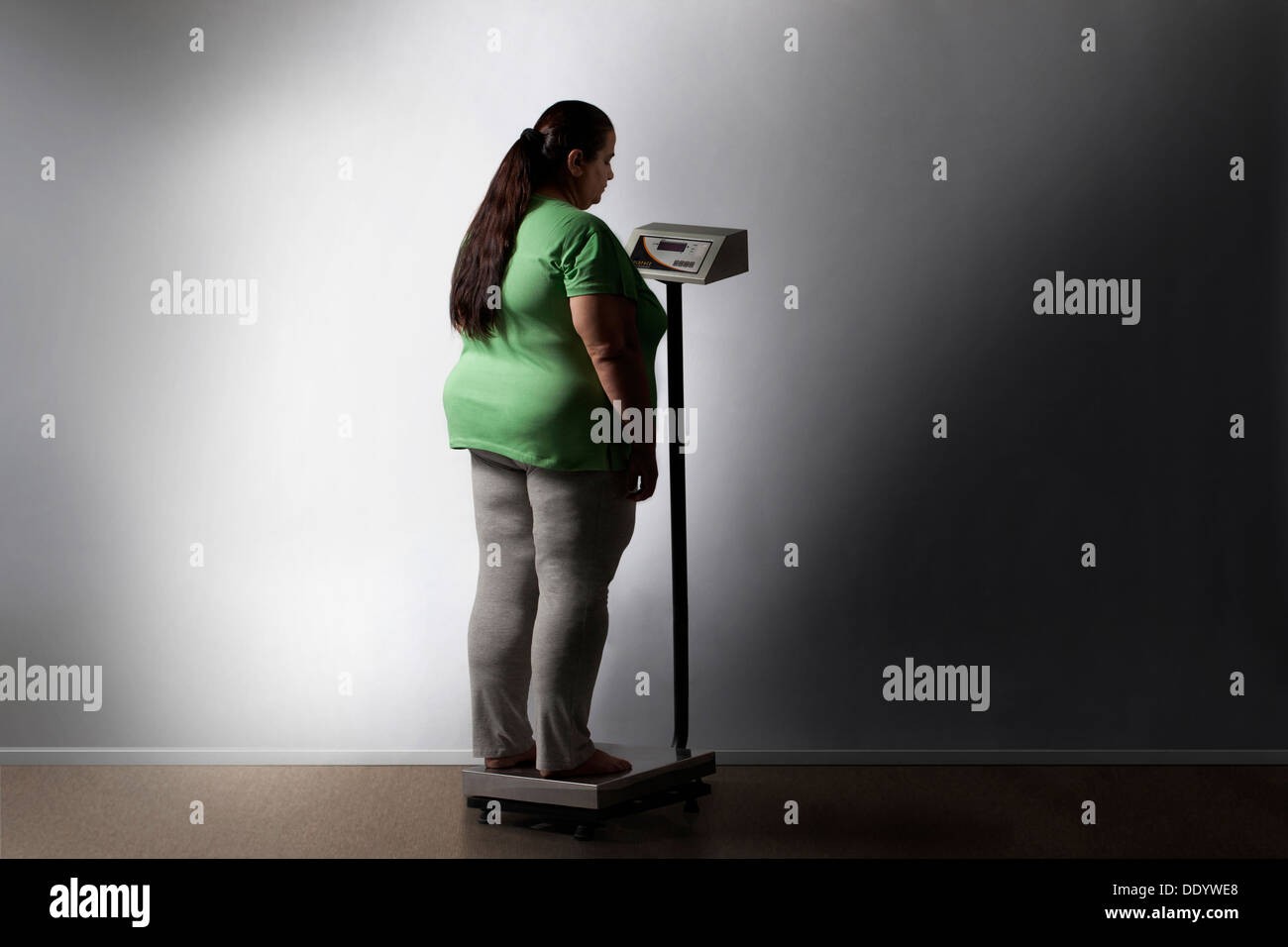 Donna obesa controllando il suo peso Foto Stock