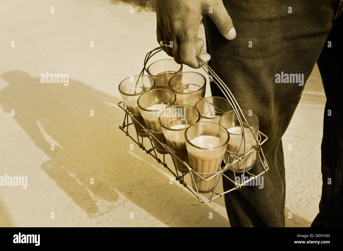Immagine monocromatica di Indian street holding bicchieri di chai nel vassoio Foto Stock
