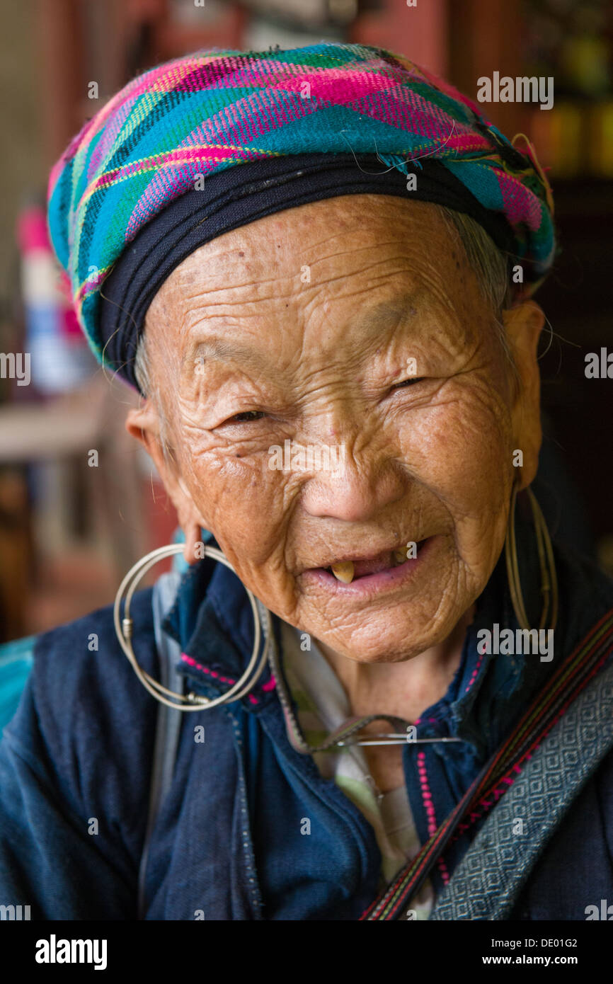 Vecchia donna Hmong con grandi orecchini e una stropicciata, foderati volto sorridente, Ta Van Village, vicino a SAPA, Vietnam Foto Stock
