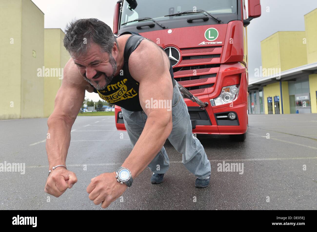 Chemnitz, Germania. 09Sep, 2013. Power sport atleta e più "trongest uomo di Germania" il detentore del titolo, Heinz Ollesch, tira un 7t carrello a Chemnitz, Germania, 09 settembre 2013. Ollesch ha fatto questo per pubblicizzare il camion tedesco tirare campionati a veicolo utilitario trade show Commcar a Chemnitz il 12 e 13 ottobre 2013. Foto: HENDRIK SCHMIDT/dpa/Alamy Live News Foto Stock