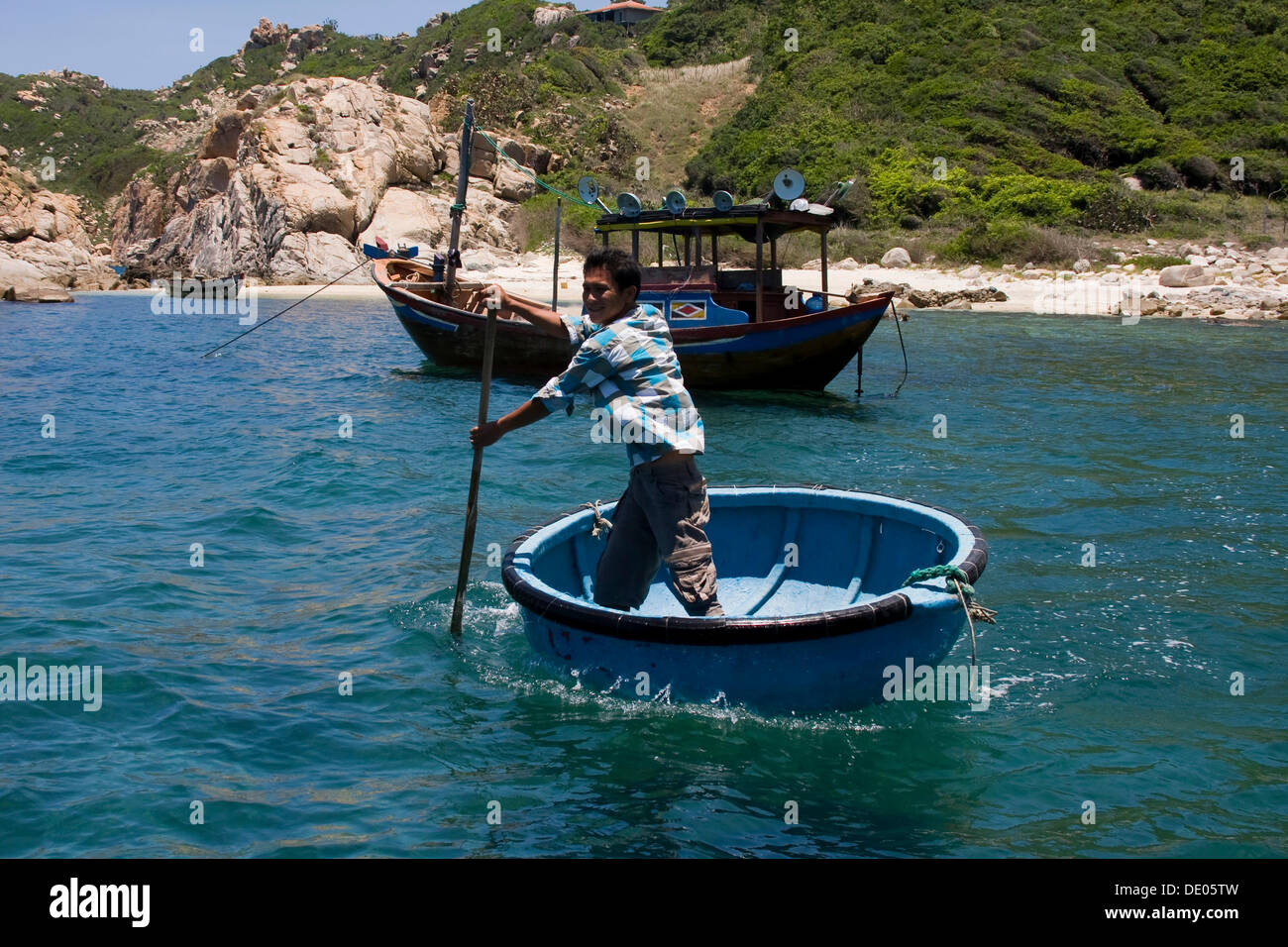 Pescatore vietnamita nel suo canestro galleggiante, Vinh Hy, Vietnam Asia Foto Stock