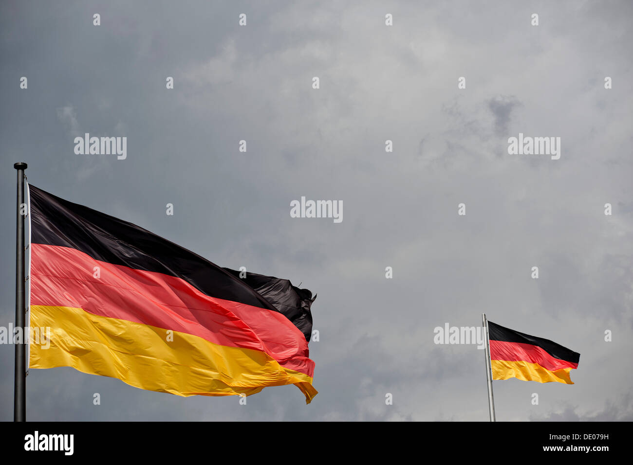 Tedesco bandiere nella parte anteriore di un oscuro cielo tempestoso, immagine simbolica Foto Stock