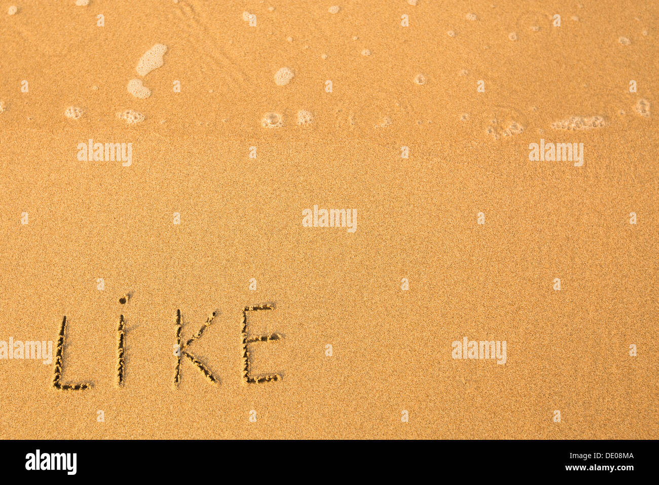 Come - testo scritto a mano in sabbia sulla spiaggia, con una morbida onda. Foto Stock