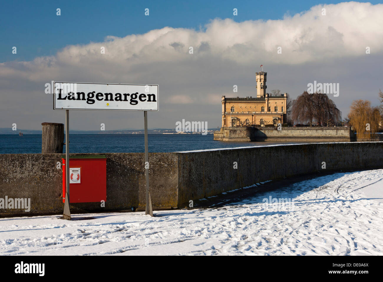 Luogo-nome sign presso il molo a Langenargen in inverno, Castello di Montfort sul retro, sul lago di Costanza Baden-Wuerttemberg Foto Stock