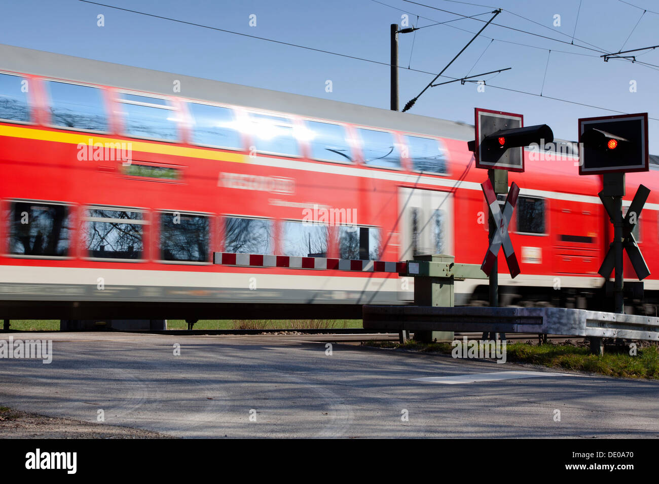 Incrocio ferroviario con treno passare Foto Stock