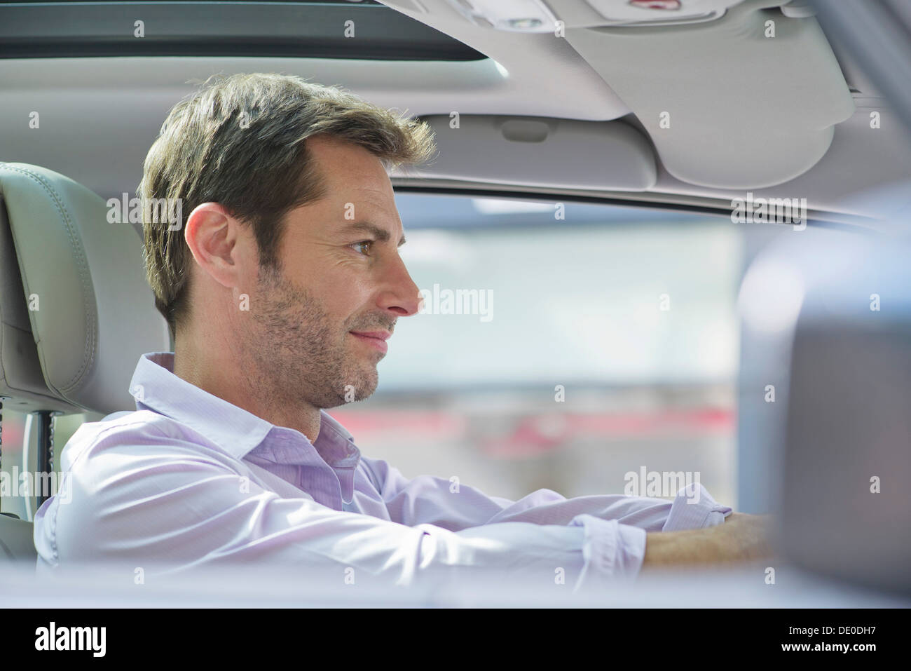 Uomo alla guida di auto, sorridente Foto Stock