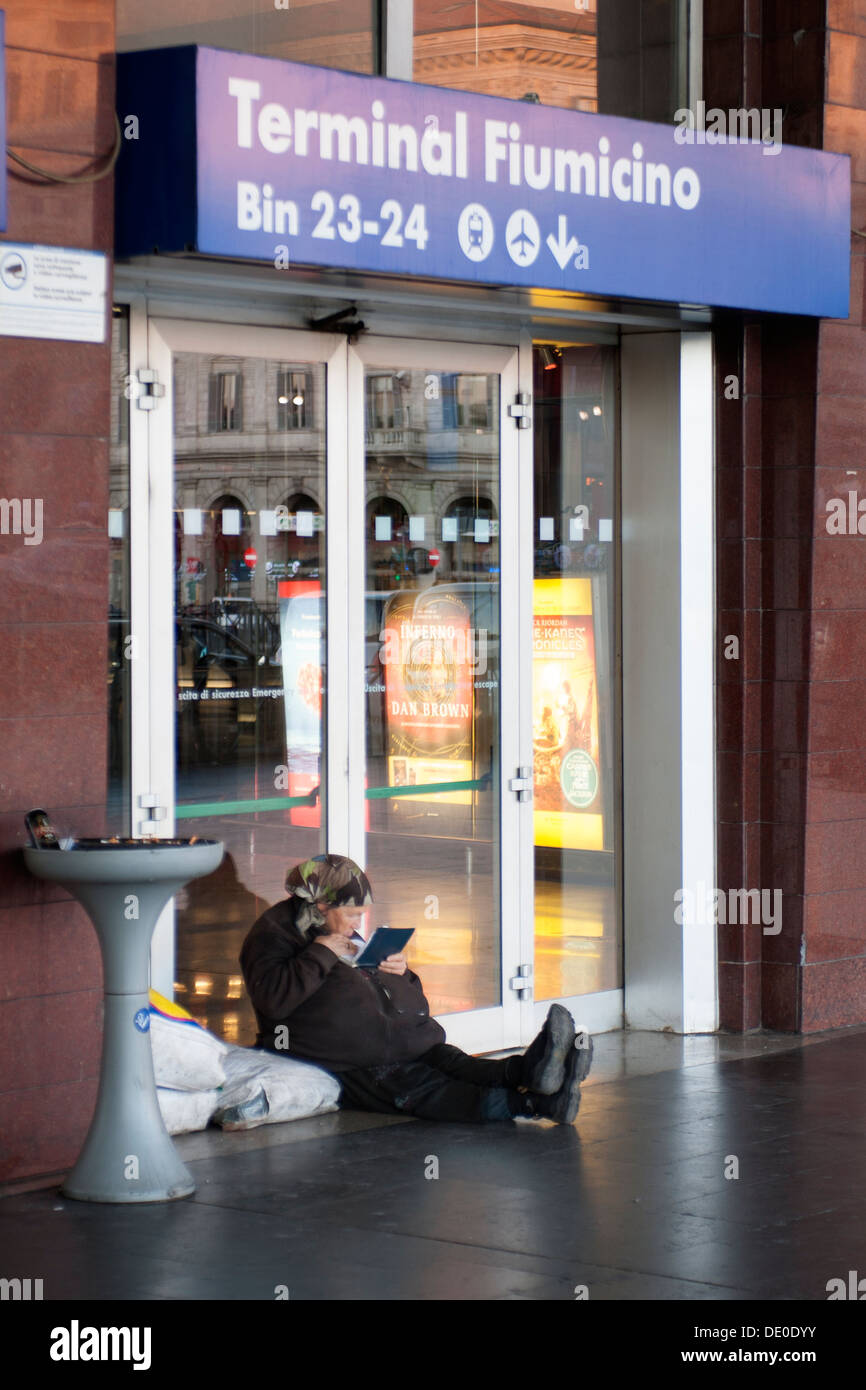 Senzatetto donna seduta al di fuori della stazione ferroviaria di Roma Foto Stock