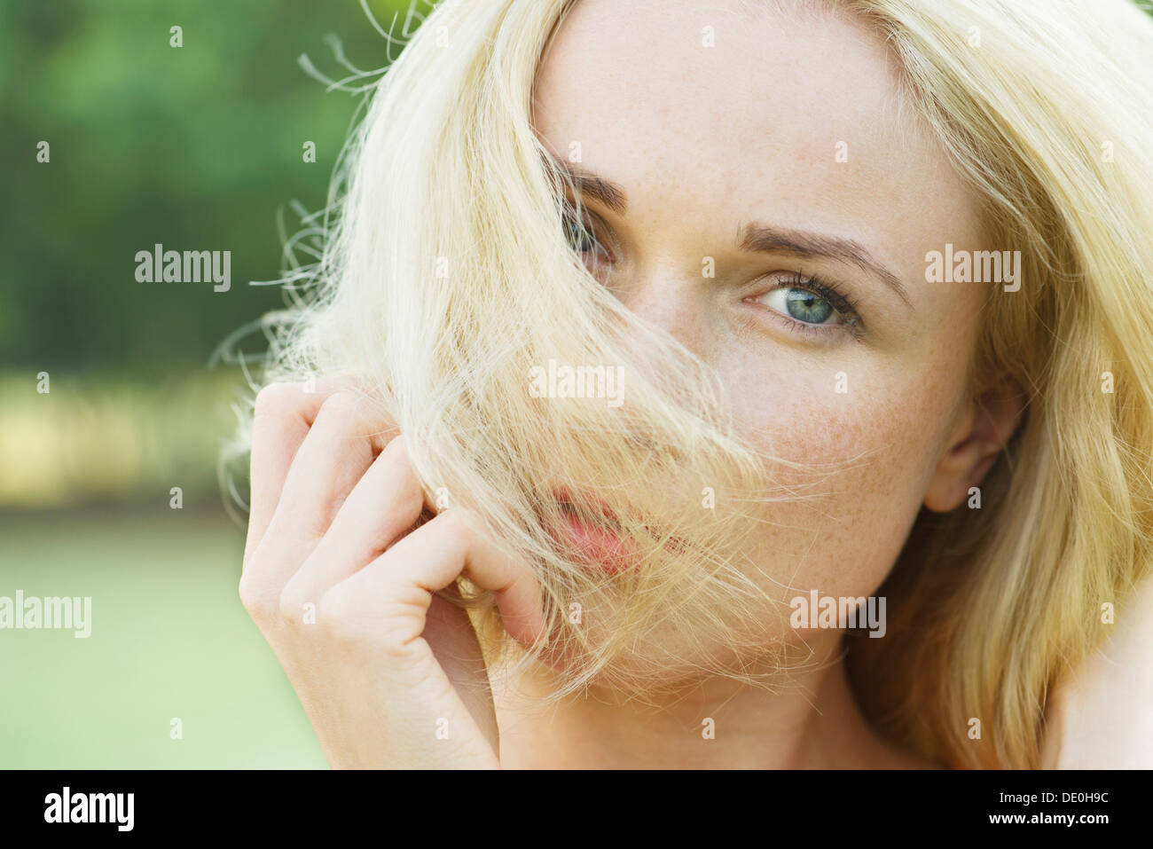 Donna che ricopre la faccia con i capelli, ritratto Foto Stock