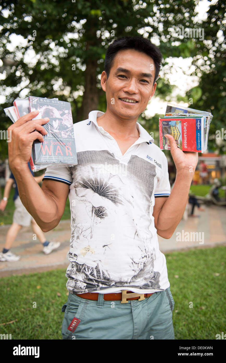 Pagaiando prenota venditore nel lago Hoan Kiem lato, Hanoi, Vietnam Foto Stock