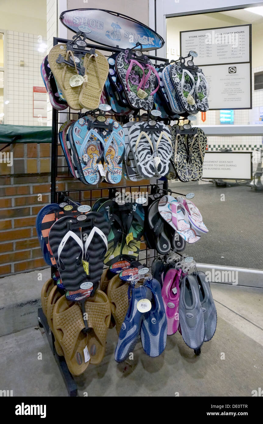 Colorato flip flop, sandali e scarpe da spiaggia per la vendita su un  espositore a rastrelliera al di fuori di un negozio Foto stock - Alamy