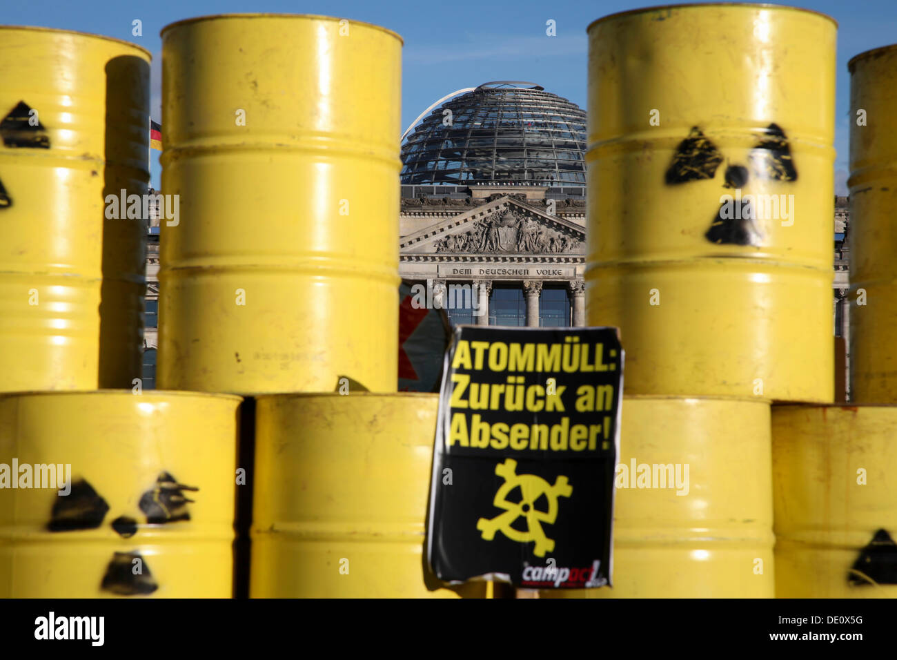 Segno, lettering "Atommuell zurueck an den Absender', tedesco per "rifiuti atomica - ritorno al mittente", una pila di rifiuti nucleari Foto Stock