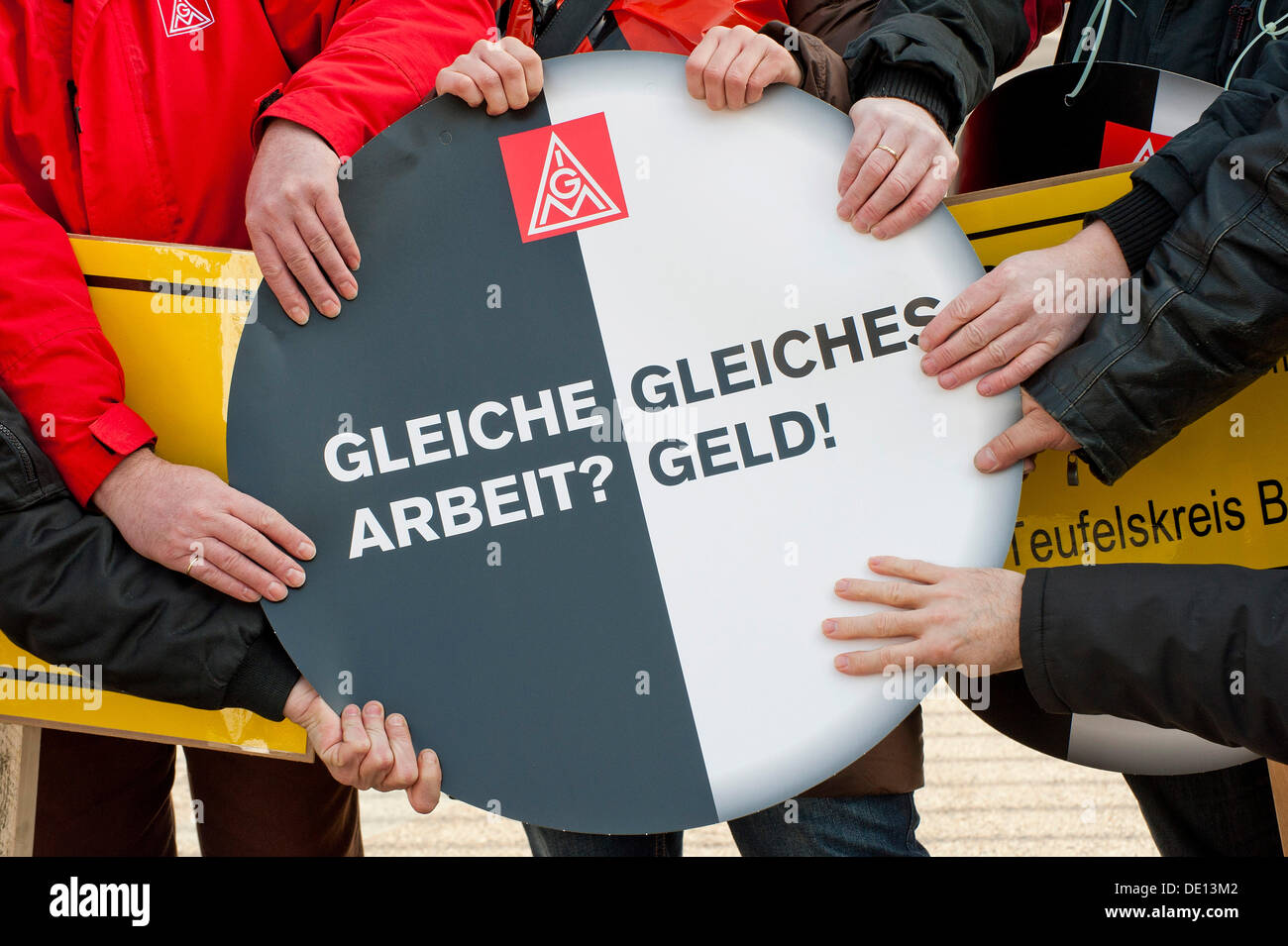 Mani tenendo il segno: 'Gleiche Arbeit? Gleiches Geld!", Tedesco per 'Same lavoro? La parità di retribuzione!', giornata di azione contro la temporanea Foto Stock