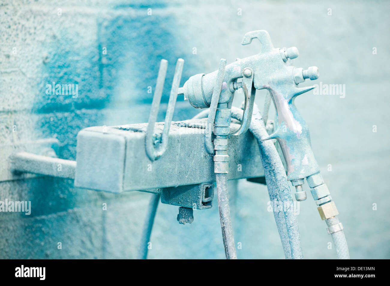 Pistola a spruzzo su una staffa a parete in un negozio di vernice Foto Stock