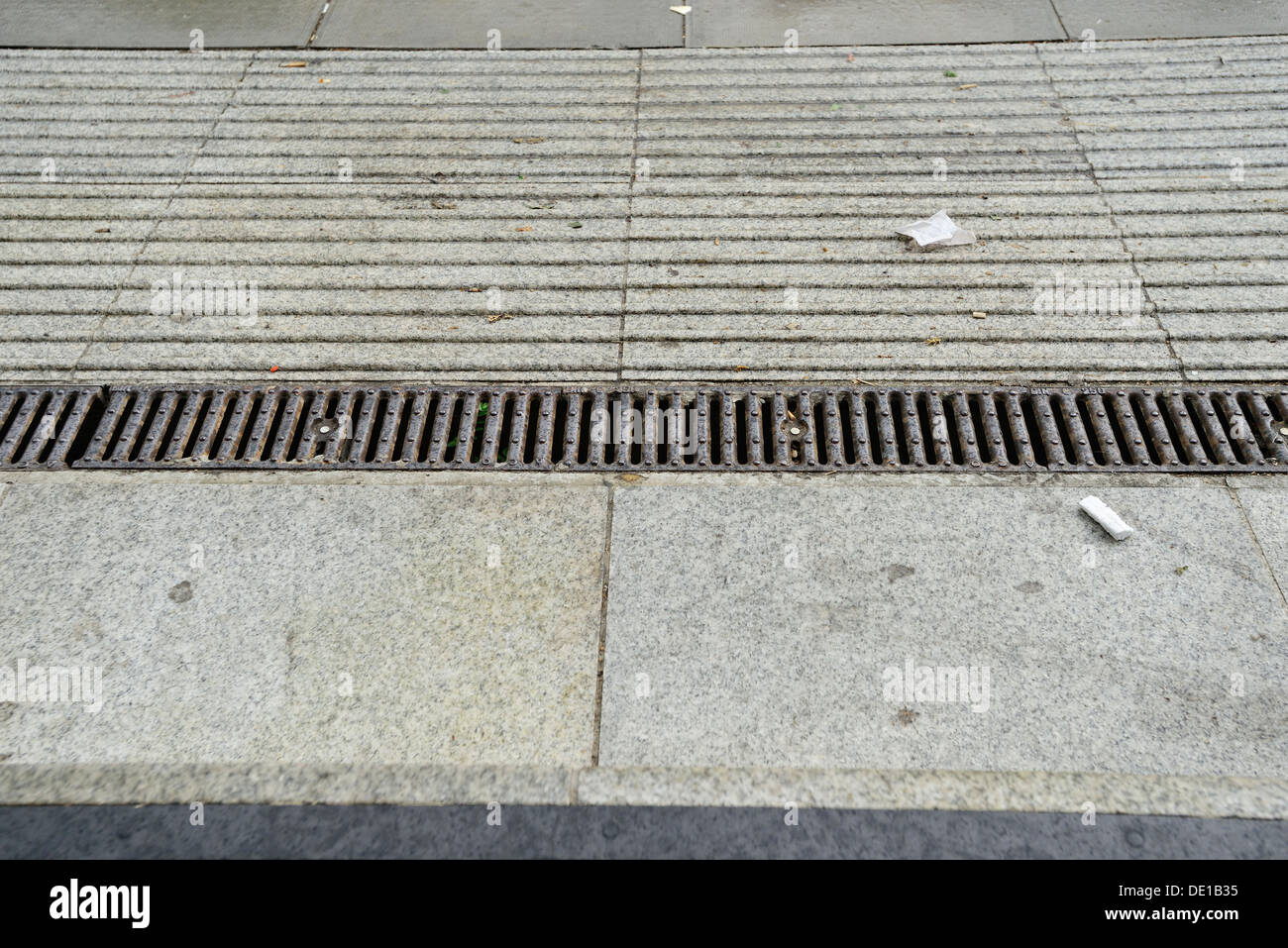 Una vista ravvicinata di una piccola canalina di drenaggio su un marciapiede Foto Stock