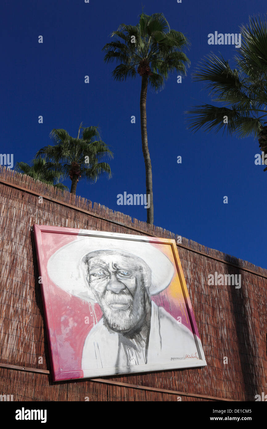 Cipro, Larnaca, ritratto, arte, pittura, quadro appeso su un recinto, viso uomo vecchio con cappello, palme Foto Stock