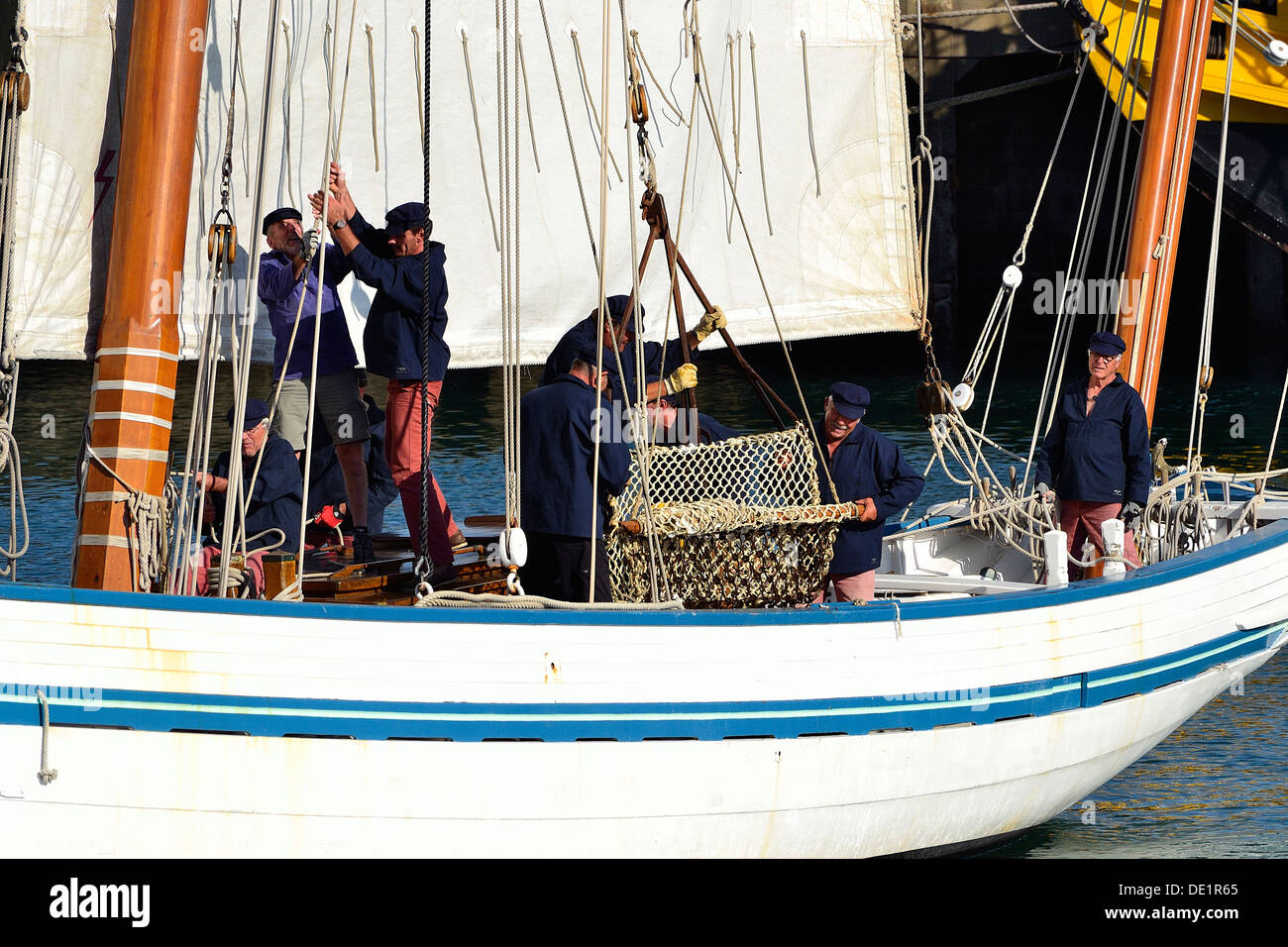 La ricostruzione di una scena lo scarico di ostriche, la pesca tradizionale barca La Granvillaise (Bisquine), a Granville (Francia). Foto Stock