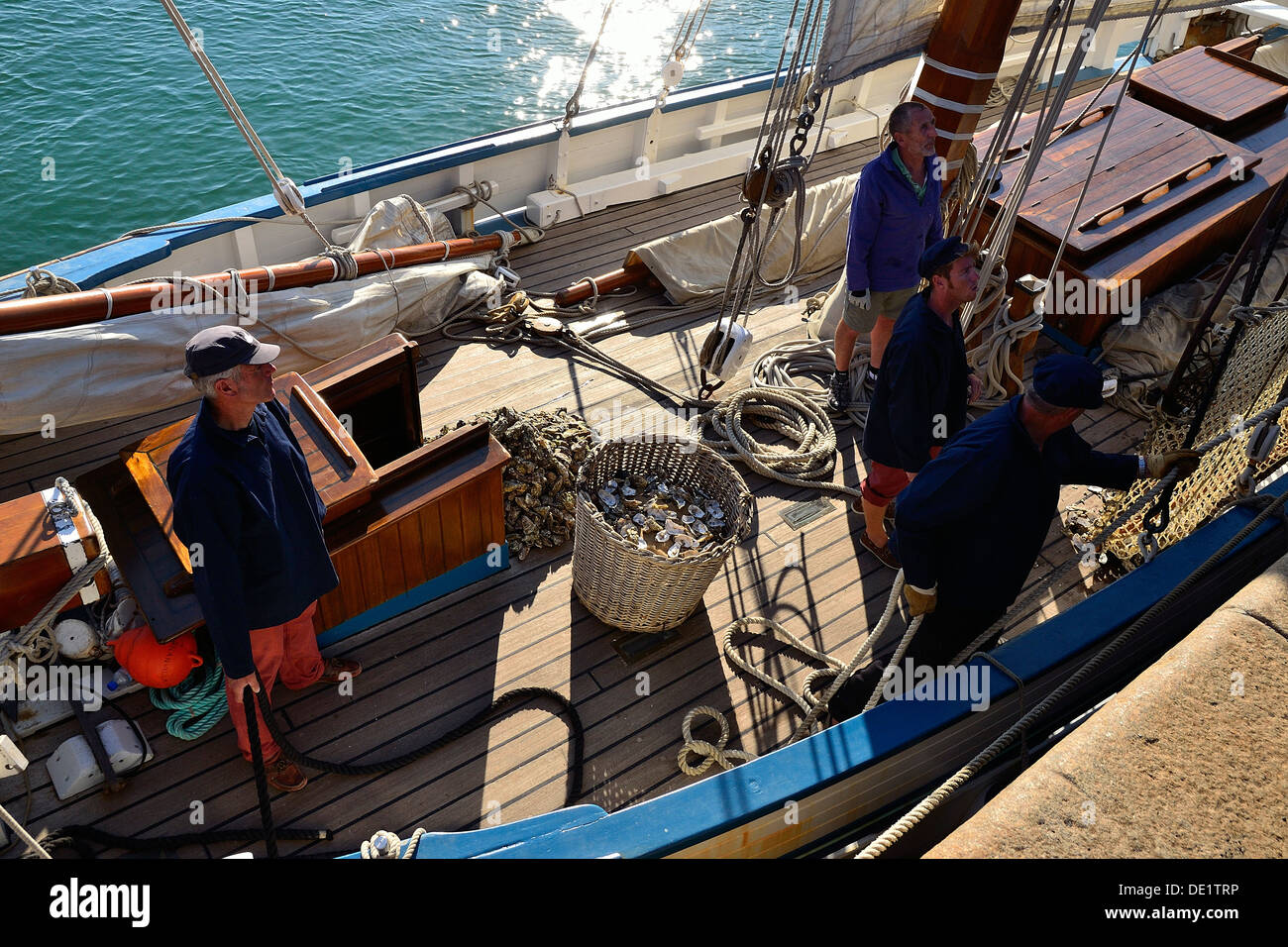 La ricostruzione di una scena lo scarico di ostriche, la pesca tradizionale barca La Granvillaise (Bisquine), a Granville. Foto Stock