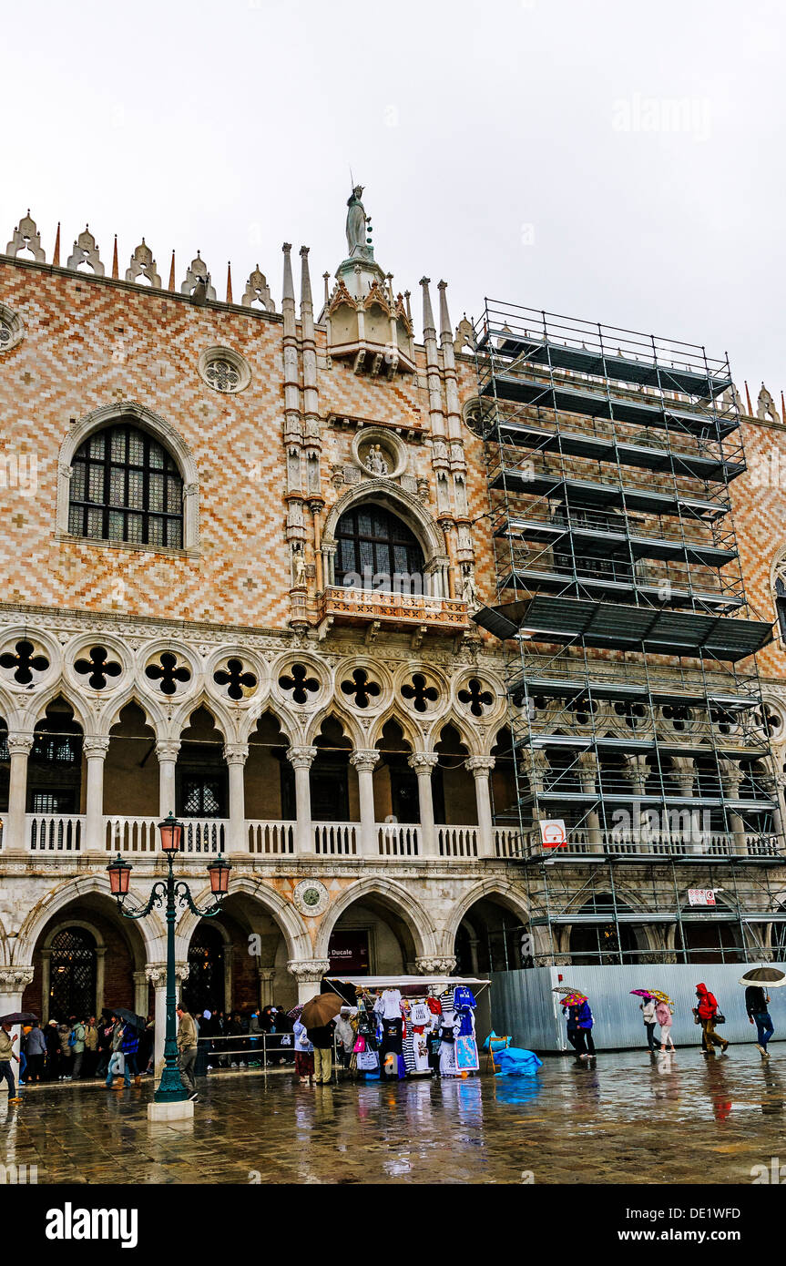 Coda di turisti in arcade a tour all'interno di Palazzo Ducale ed evitare la pioggia è caduta sulla piazzetta di San Marco Foto Stock