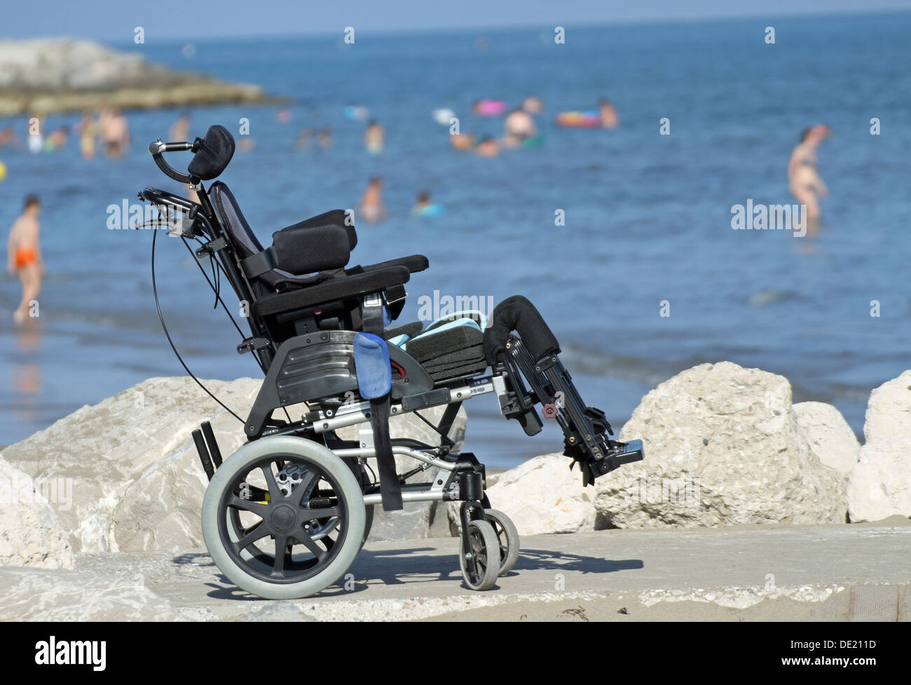 Nuova sedia a rotelle per disabili sul pontile di rocce di mare in estate 3 Foto Stock