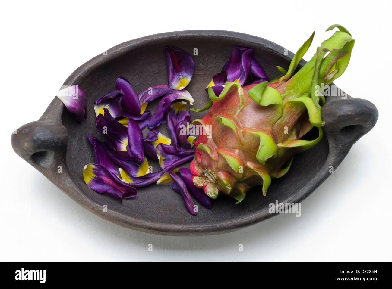 Red Pitaya (Hylocereus undatus) e petali di un tulipano in un arcaico ciotola di argilla Foto Stock