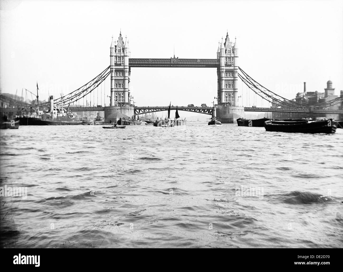 Il Tower Bridge con parti sollevabili chiuso e chiatte passando sotto in acqua alta, Londra, c1905. Artista: sconosciuto Foto Stock