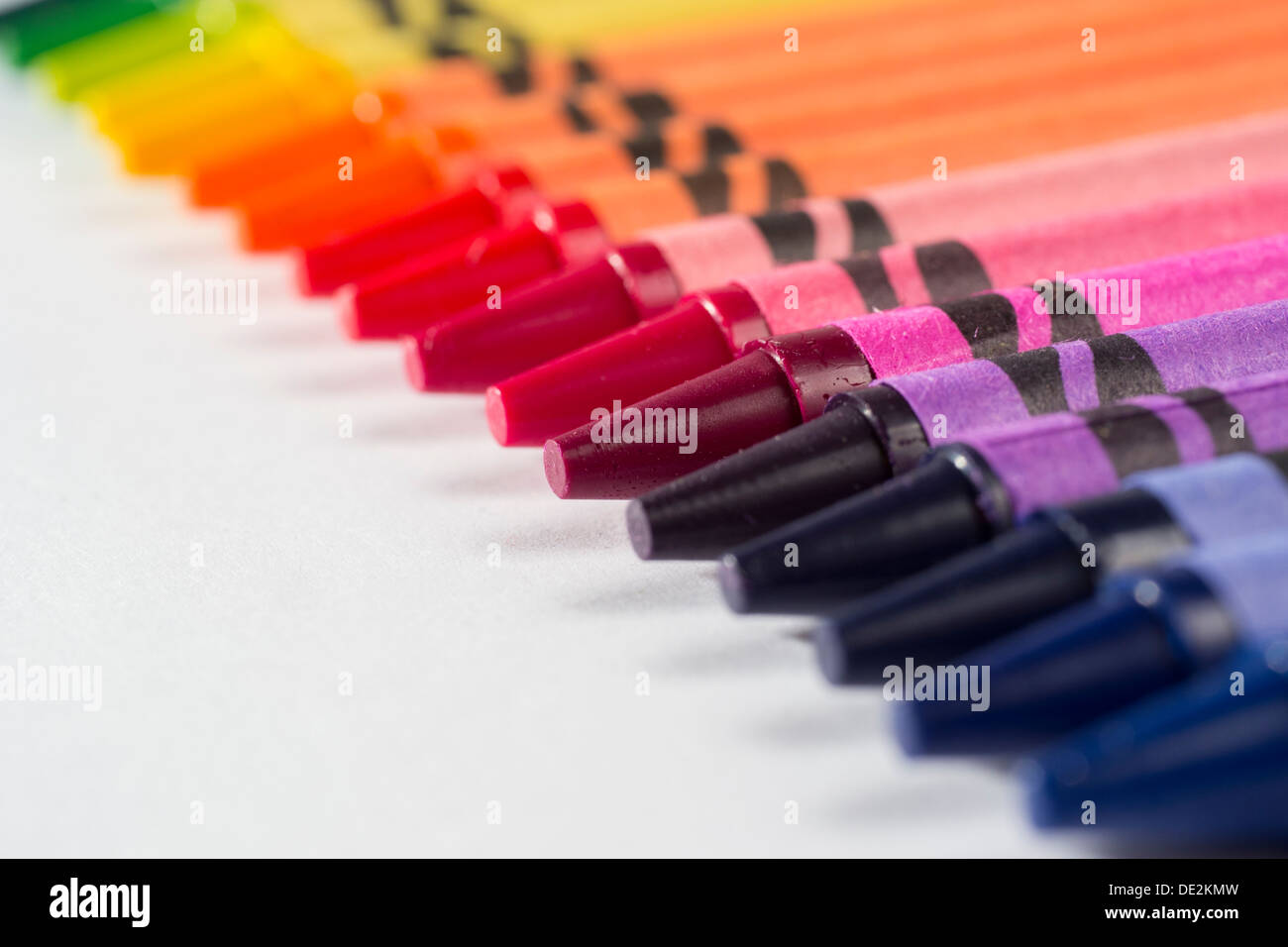 Matite colorate posa in una fila di mostrare unità e diversità, stare insieme, o il lavoro di squadra Foto Stock
