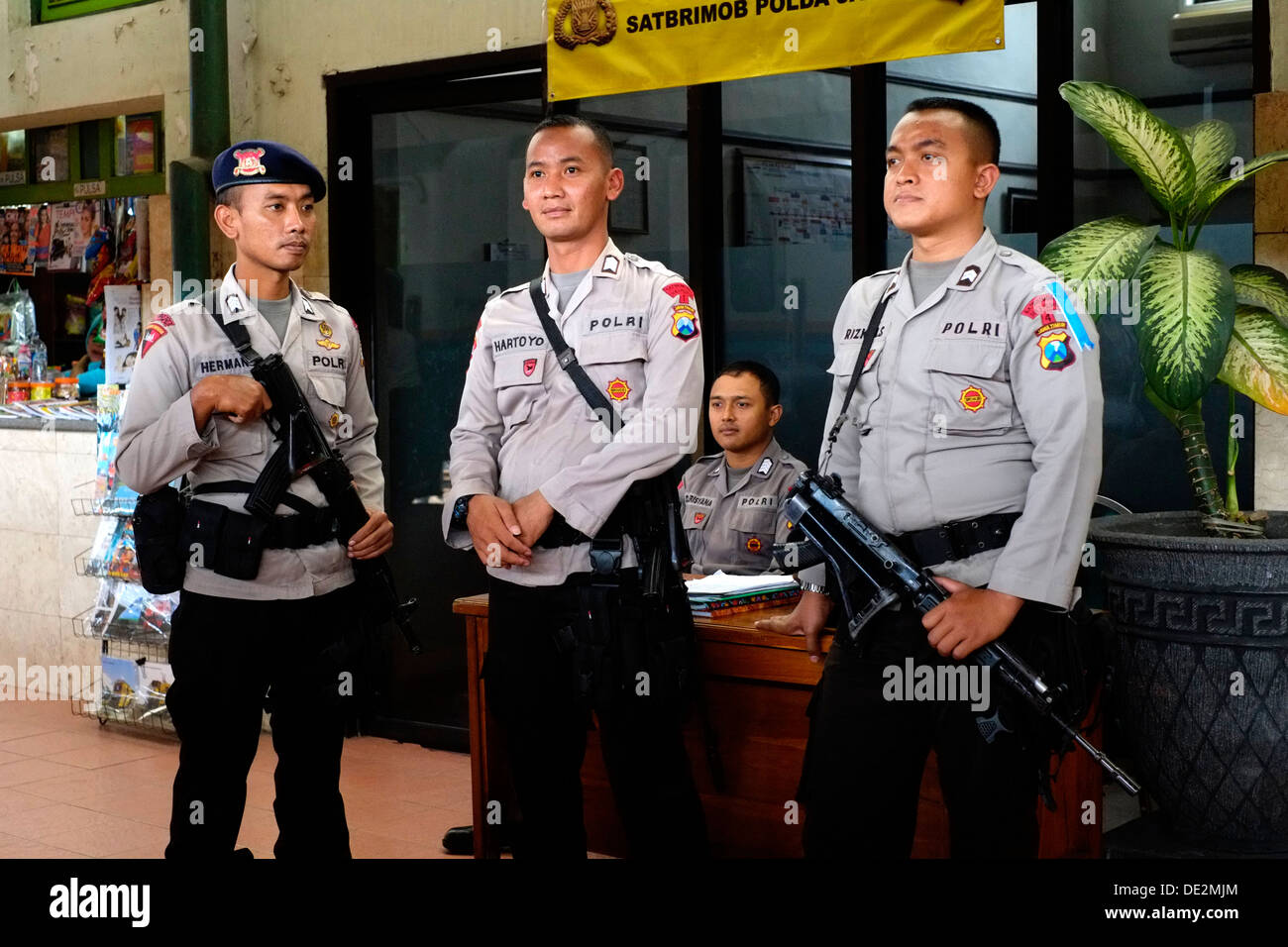 Polizia armata di tenere un occhio sui passeggeri a malang trafficata Stazione ferroviaria durante la trafficata idul fitri holiday getaway java indonesia Foto Stock