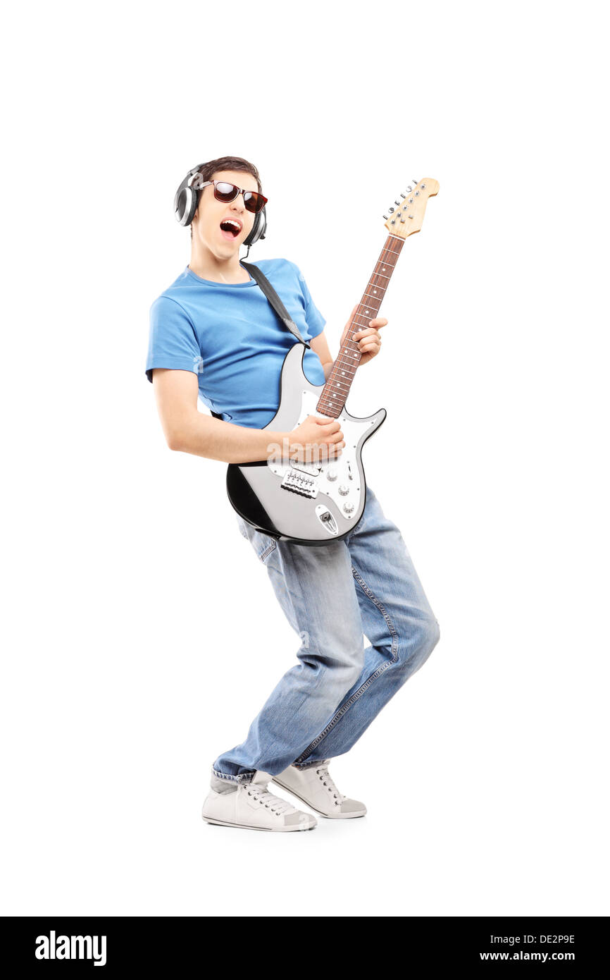 A piena lunghezza Ritratto di un musicista maschio con cuffie suonando una chitarra elettrica Foto Stock