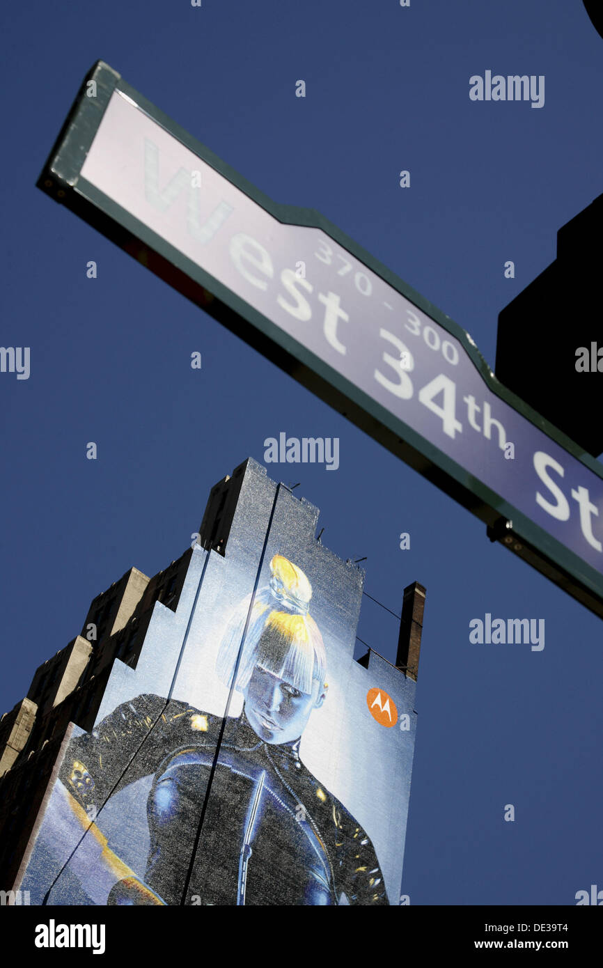 Pubblicità su un edificio di superficie con un cartello stradale in primo piano, New York City. Stati Uniti d'America Foto Stock