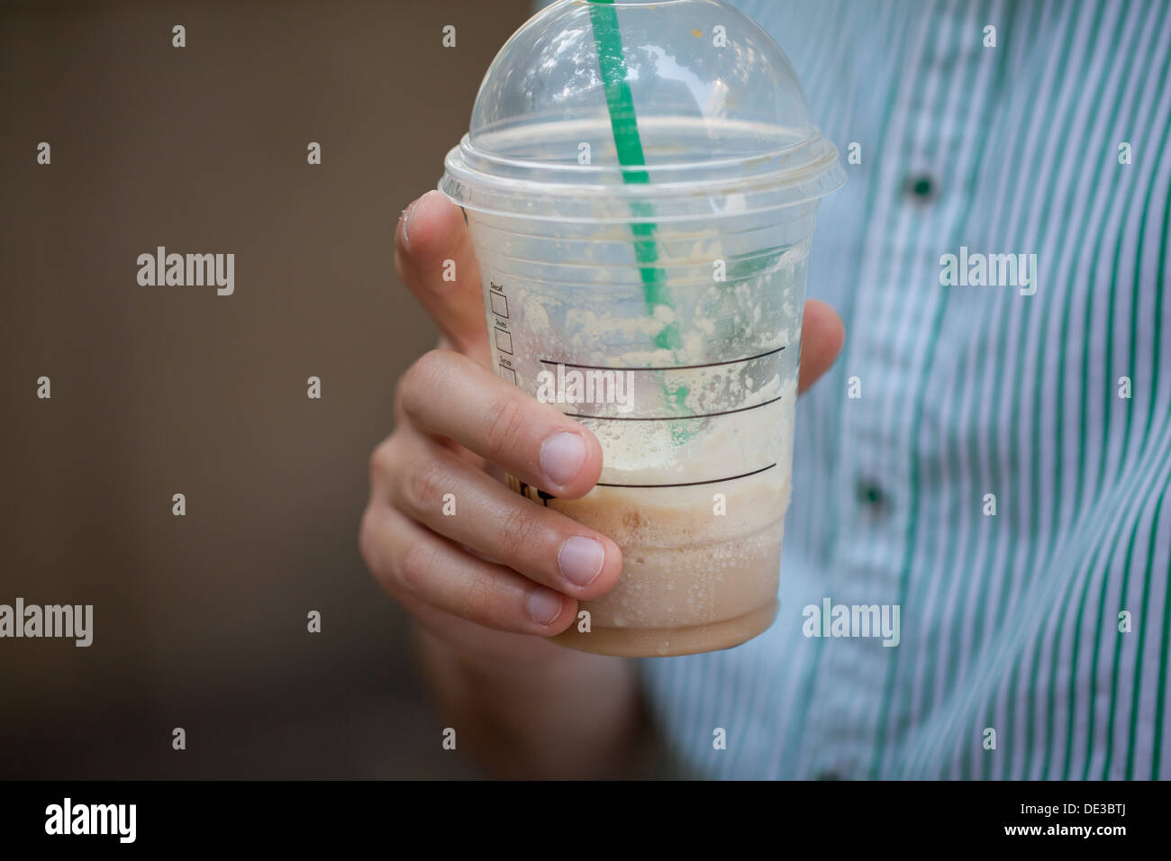 Uomo con un caffè ghiacciato drink in mano Foto Stock