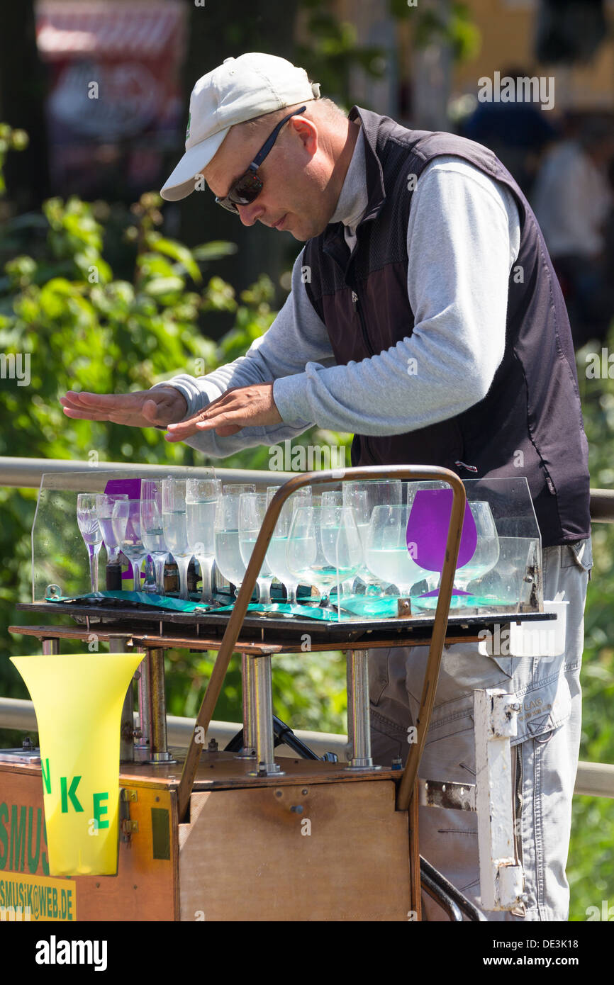 L'uomo la riproduzione di musica tramite un 'armonica di vetro' Warnemunde Rostock Germania Foto Stock