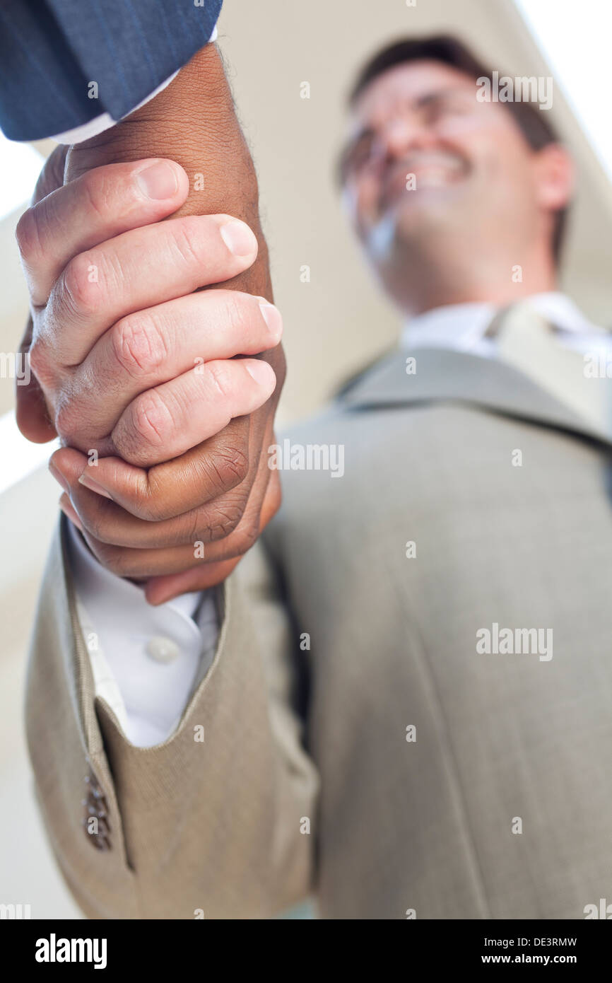 Imprenditore caucasico o man mano tremante con un americano africano collega facendo un affare Foto Stock
