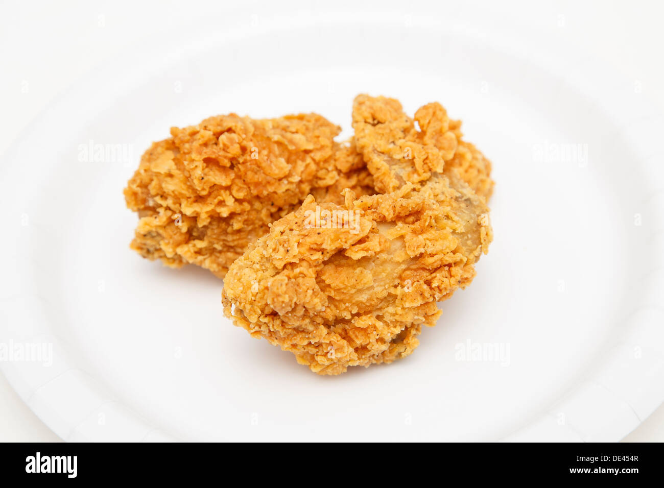 Due fresche fritte le strisce di pollo su una piastra bianca Foto Stock