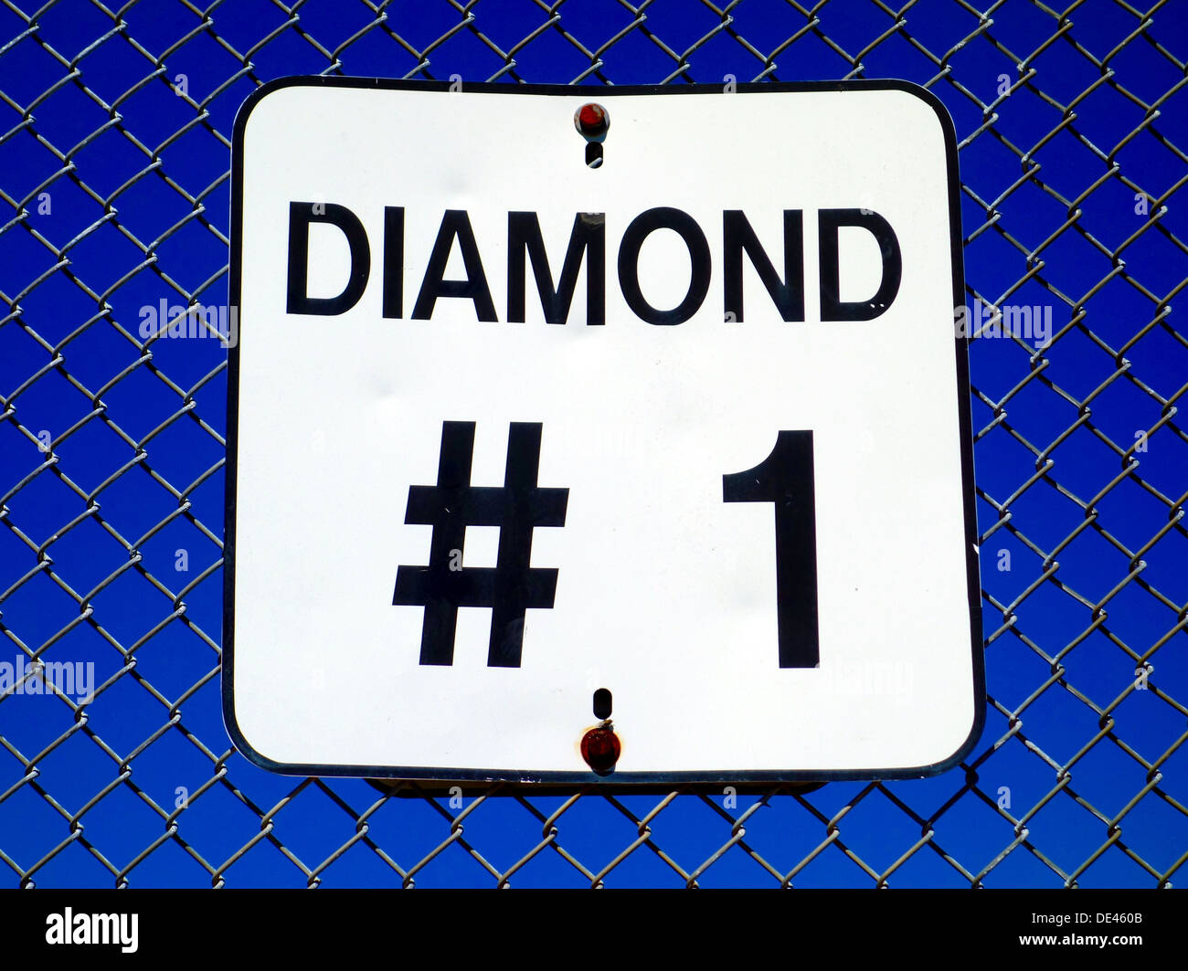 Segno su una recinzione presso l'entrata di un diamante di baseball in un parco suburbano Foto Stock