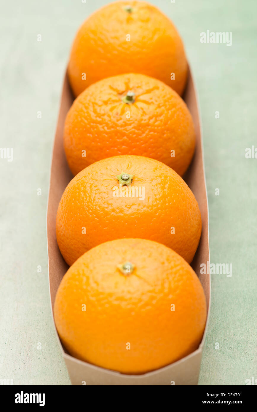 Delizioso e fresco, succoso e appetitoso arance navel disposti in una scatola di cartone su una superficie in legno Foto Stock