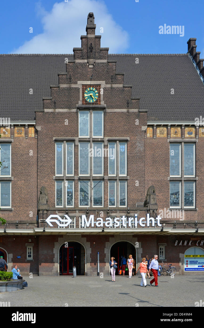 Stazione ferroviaria della città di Maastricht edificio in mattoni e orologio persone fuori dall'ingresso principale e cartello con il logo del marchio Summer in Limburg Paesi Bassi Europa e UE Foto Stock