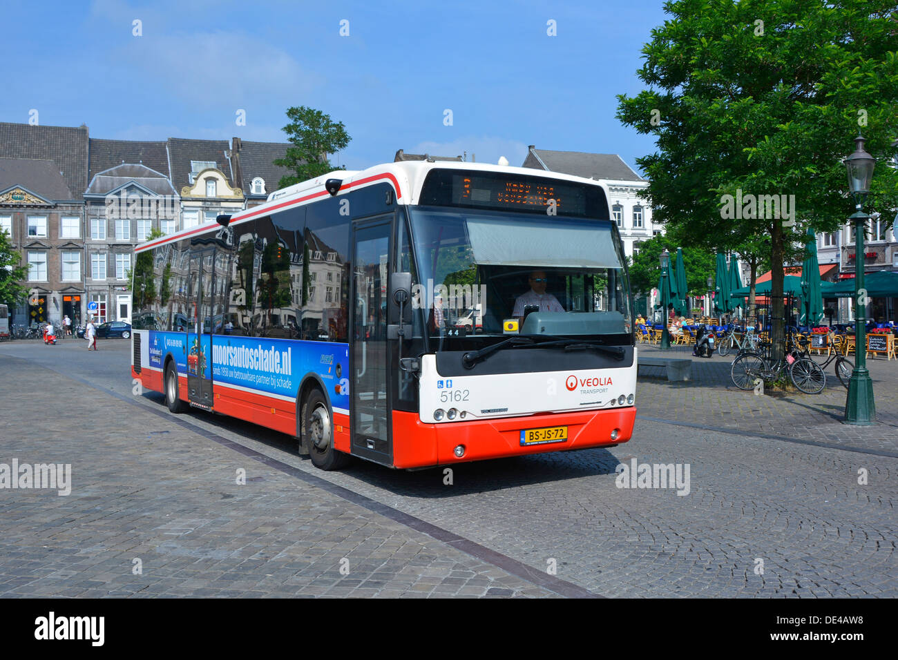 Autobus a un piano della città di Maastricht gestito dall'azienda Veolia Transport, vista ravvicinata che guida lungo la superficie stradale acciottolata Limburgo Paesi Bassi Europa e UE Foto Stock