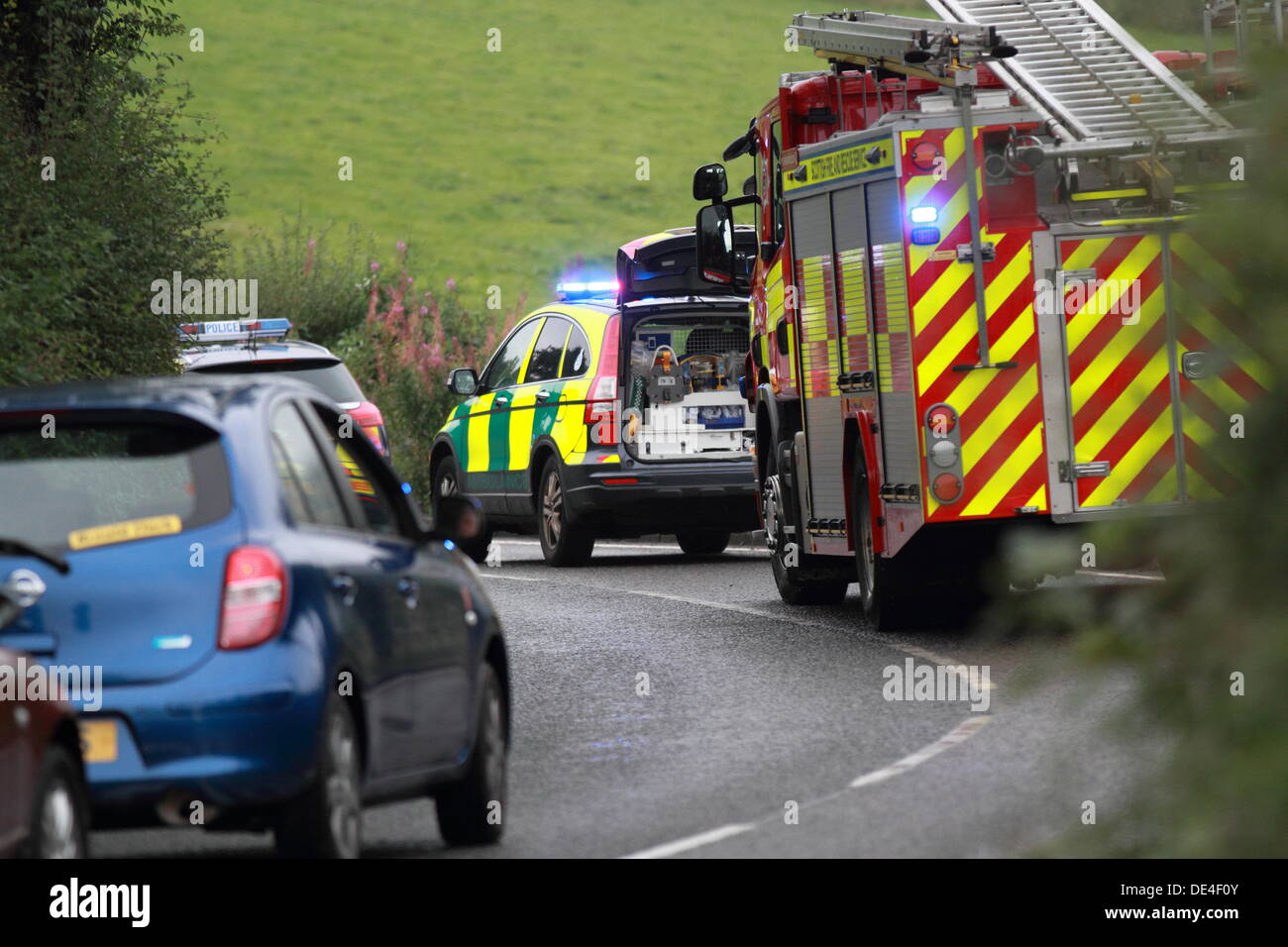 B822, Manchester, Glasgow, Scotland, Regno Unito - Auto si blocca nel campo e i servizi di emergenza vicino strada al conducente di salvataggio. Foto Stock