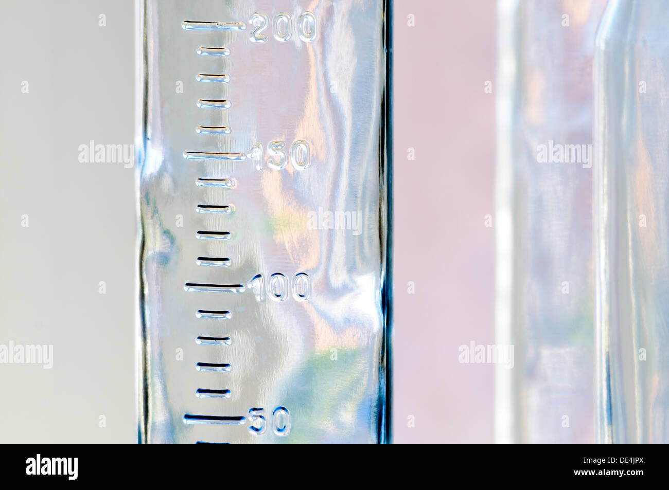Close-up di un laureato bottiglia di vetro con riflessi colorati Foto Stock